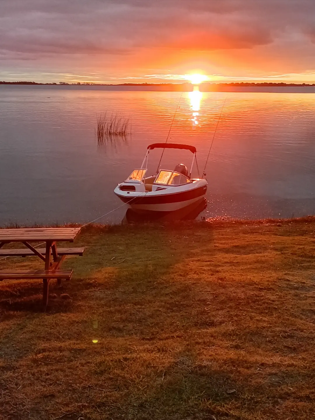 Un bote en la laguna al caer el sol.