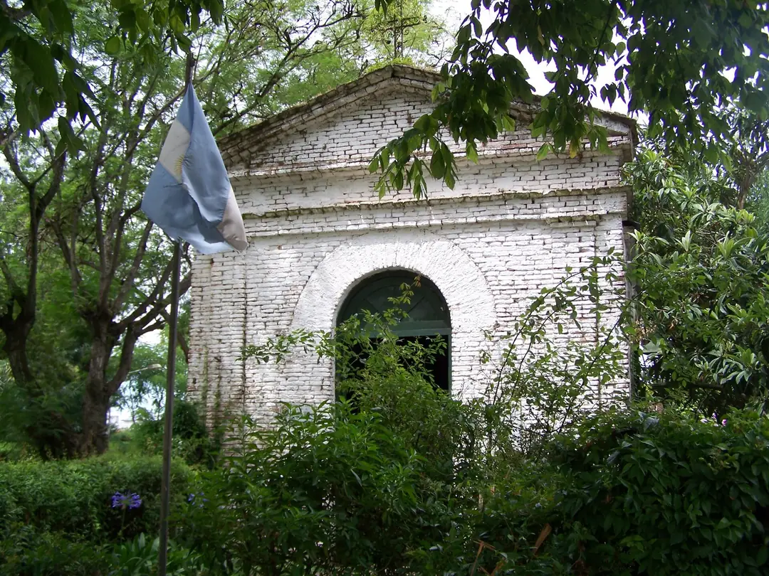 La Capilla de los Negros, pequeña y blanca, entre la vegetación.