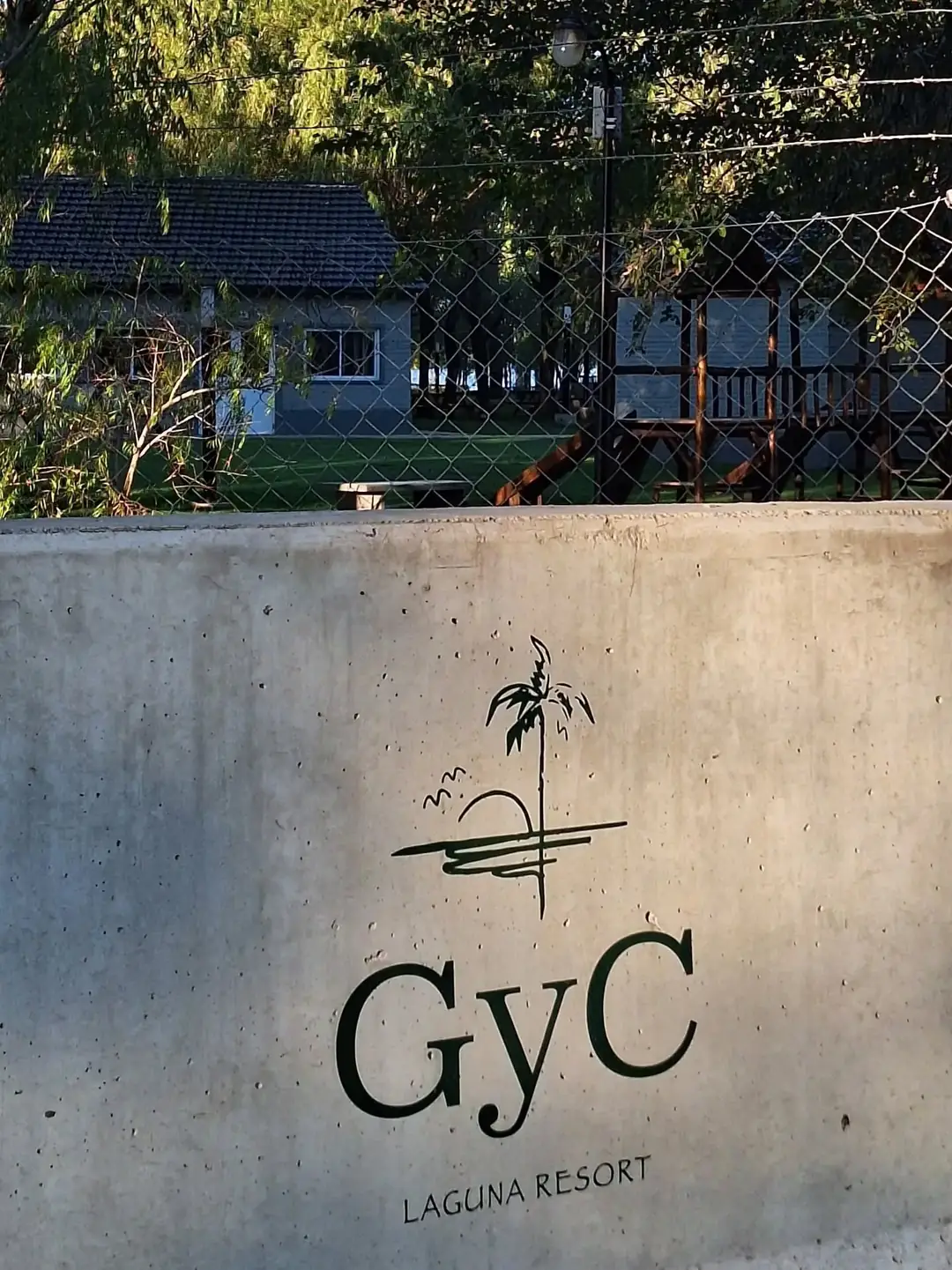 El cartel de GyC en la entrada, sobre un muro de hormigón.